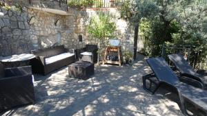 a patio with couches and benches and a stone wall at Beliving House in Mandra Capreria