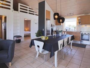 a kitchen and dining room with a table and chairs at 8 person holiday home in V ggerl se in Marielyst