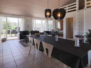 a dining room with a black table and chairs at 8 person holiday home in V ggerl se in Marielyst