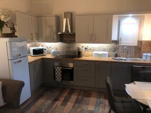 a kitchen with brown cabinets and a white refrigerator at The Coop in Castle Douglas