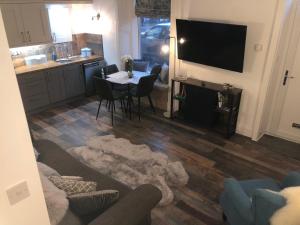a kitchen and living room with a table and a television at The Coop in Castle Douglas