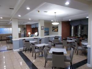 a restaurant with tables and chairs and a bar at SureStay Plus Hotel by Best Western St Marys Cumberland in Saint Marys