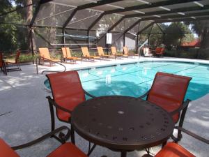 a table and chairs in front of a swimming pool at SureStay Plus Hotel by Best Western St Marys Cumberland in Saint Marys