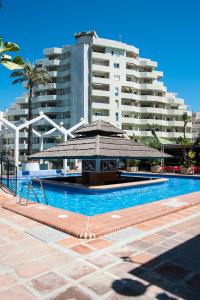 a swimming pool in front of a large building at Kingfisher Apartments Benal Beach in Benalmádena