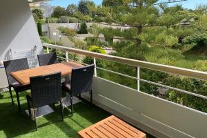 een patio met een tafel en stoelen op een balkon bij 4 pers , 100m de la plage marina baie des anges French Riviera in Villeneuve-Loubet