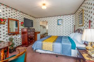 Dormitorio con cama, escritorio y TV en Parkway Inn, en Waynesville
