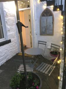 a patio with a table and chairs and lights at The Coop in Castle Douglas