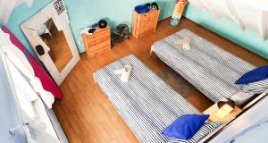 a bedroom with two beds and a wooden floor at Ericeira Surf Camp in Ericeira