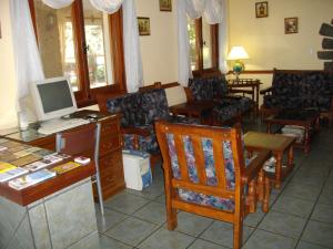 Hotel San Juan في فيلا جياردينو: غرفة بها مكتب وبه جهاز كمبيوتر وكراسي
