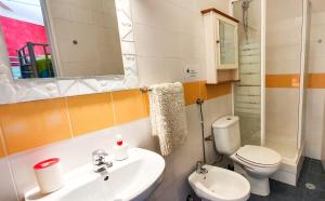 a bathroom with a sink and a toilet and a mirror at Ericeira Surf Camp in Ericeira
