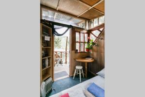 Kleines Zimmer mit einem Tisch und einem Schreibtisch. in der Unterkunft The Treehut in Island Bay