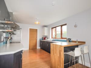een keuken met zwarte kasten en een houten aanrecht bij 3 Croftside in Aviemore
