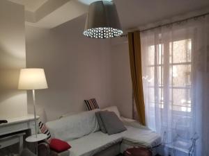 uma sala de estar com um sofá branco e uma janela em La Traboule Vieux Lyon em Lyon