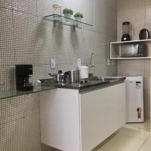 a kitchen with a counter and a sink and a refrigerator at Flats Integração in Petrolina