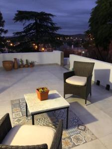 d'une terrasse avec deux chaises, une table et une table. dans l'établissement URBANO TAJAMAR, à Alta Gracia