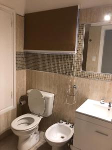 een badkamer met een wit toilet en een wastafel bij URBANO TAJAMAR in Alta Gracia