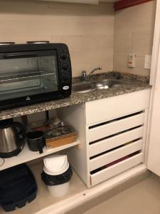 a kitchen with a sink and a microwave at URBANO TAJAMAR in Alta Gracia +5 photos
