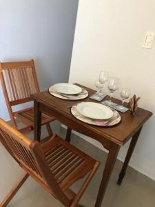 - une table en bois avec 2 assiettes et des verres à vin dans l'établissement URBANO TAJAMAR, à Alta Gracia
