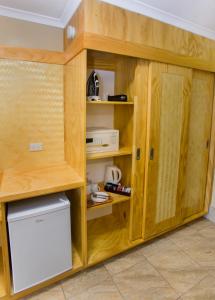 a kitchen with wooden cabinets and a refrigerator at The Edgewater Resort & Spa in Rarotonga