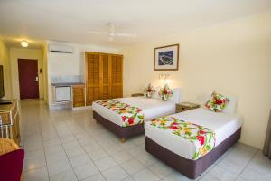 a hotel room with two beds and a kitchen at The Edgewater Resort & Spa in Rarotonga