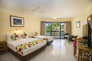 a hotel room with two beds and a balcony at The Edgewater Resort & Spa in Rarotonga