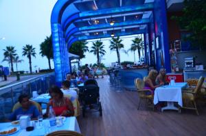 a group of people sitting at tables at a restaurant at Kleopatra Balik Hotel in Alanya