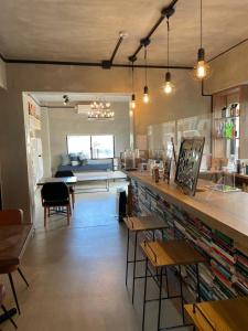 a room with a bar with tables and a couch at Book Tea Bed IZUOSHIMA in Oshima