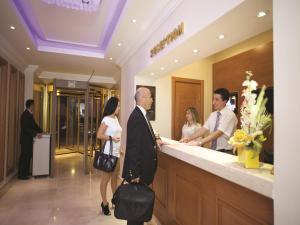 a group of people standing at a counter in a lobby at The City Hotel in Istanbul