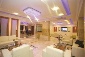 eine Lobby mit weißen Sofas und einem TV in der Unterkunft The City Hotel in Istanbul