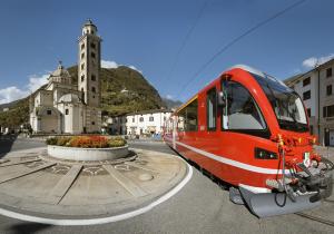 a red train is parked in front of a building at Hotel Bellavista in Teglio