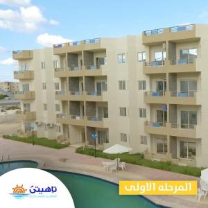 an apartment building with a pool in front of it at Tahiti North cost تاهيتي الساحل الشمالي in Al Ḩammām +1 photo