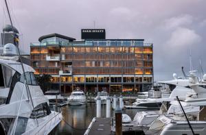 a hotel with boats docked in front of a marina at Park Hyatt Auckland in Auckland