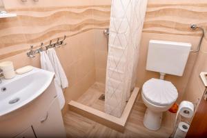 a small bathroom with a toilet and a sink at Apartments Ruza in Ražanj +30 photos