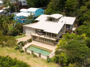 - une vue aérienne sur une maison avec une piscine dans l'établissement Stanwell Beach Glass House, à Stanwell Park