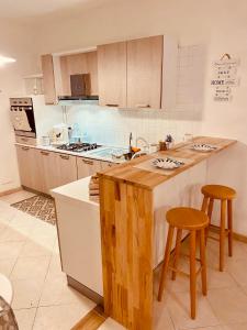 une cuisine avec un comptoir et deux tabourets dans l'établissement B&B Le Quattro Stagioni, à La Maddalena