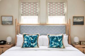 a bedroom with a large bed with blue pillows at Faraway Nantucket in Nantucket
