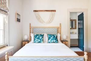 a bedroom with a large bed with blue pillows at Faraway Nantucket in Nantucket