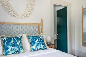 a bedroom with a bed with blue pillows and a mirror at Faraway Nantucket in Nantucket