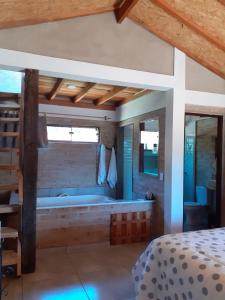 Schlafzimmer mit Badewanne und Bett in der Unterkunft Chalé aconchegante com hidromassagem in Santo Antônio do Pinhal