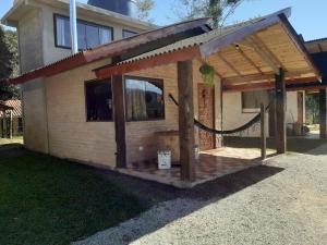 ein kleines Haus mit einer Veranda mit einem Dach in der Unterkunft Chalé aconchegante com hidromassagem in Santo Antônio do Pinhal