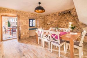 a kitchen and dining room with a wooden table and chairs at Villa Frank - with pool in Vrbnik