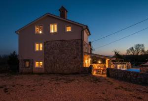 a large house with its lights on at night at Villa Frank - with pool in Vrbnik