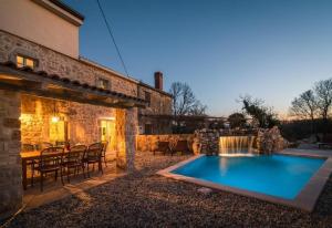 a pool in a yard with a table and chairs at Villa Frank - with pool in Vrbnik