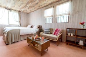 a bedroom with a bed and a couch and a table at Palm Springs Miyakojima Resort in Miyako Island