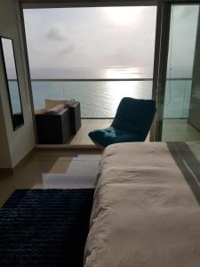 a bedroom with a bed and a chair in front of a window at H2 Hyatt Vista Mar!! in Cartagena de Indias +20 photos