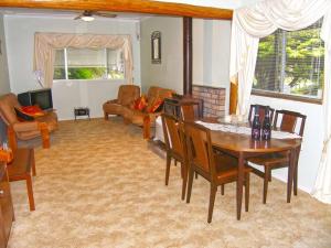 uma sala de estar com uma mesa de madeira e cadeiras em CHAP14C - Chapman Cottage em Myola