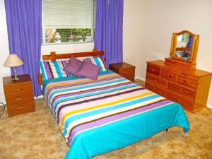 um quarto com uma cama com um espelho e cortinas roxas em CHAP14C - Chapman Cottage em Myola