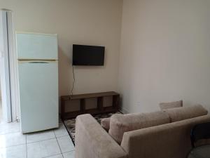 een woonkamer met een bank en een koelkast bij Residencial Joed 4 in Dourados