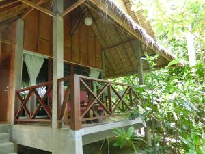 una casa con portico in legno e balcone di The Narima - SHA Plus a Ko Lanta