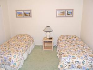 een kamer met 2 bedden en een tafel met een lamp bij ORSO1O - Water View House in Greenwell Point